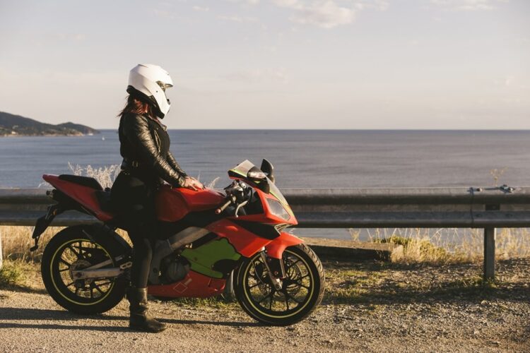Italy, Elba Island, female motorcyclist at viewpoint